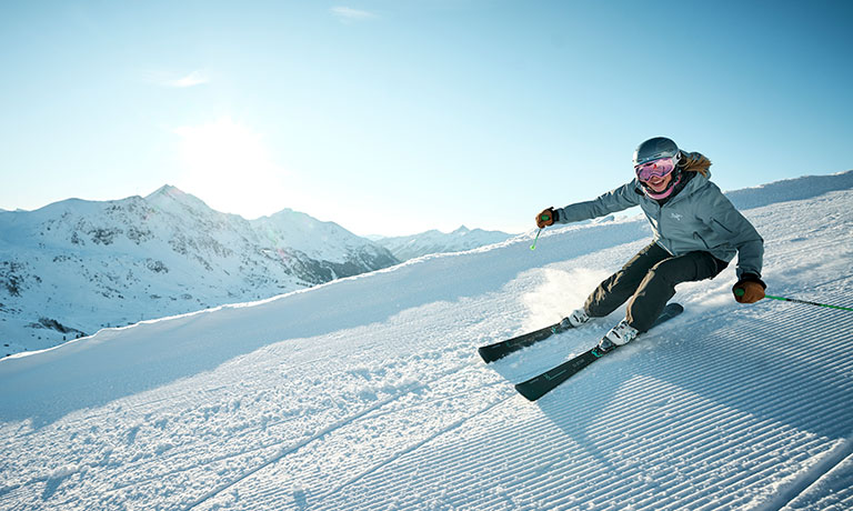 Ein Skifahrer, der eine Piste hinunterfährt