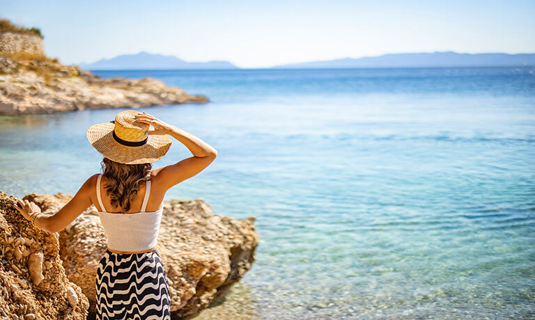 a woman sitting on a rock in the water