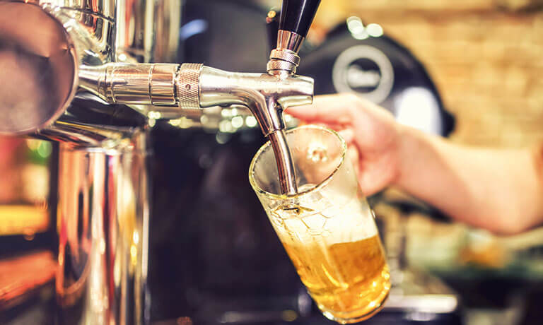 a person pouring liquid into a glass