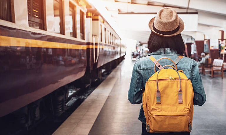 a person in a hat waiting for a train