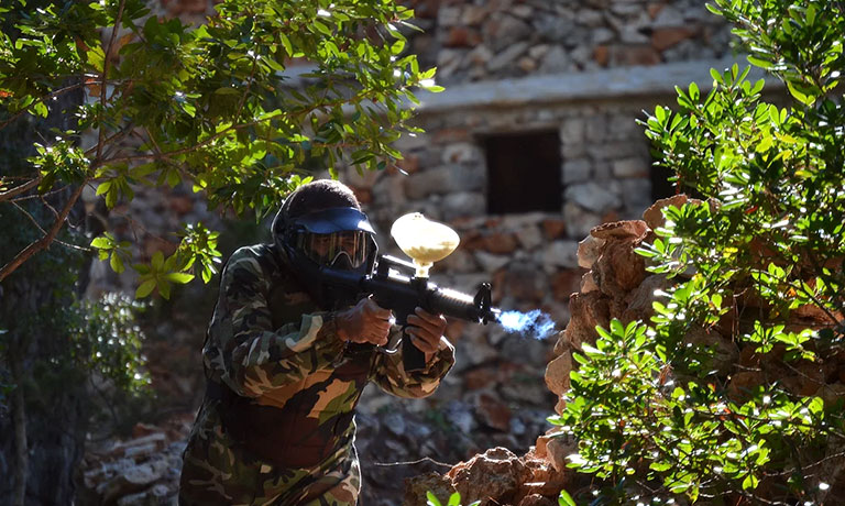 Eine Person mit Helm, die eine Waffe hält