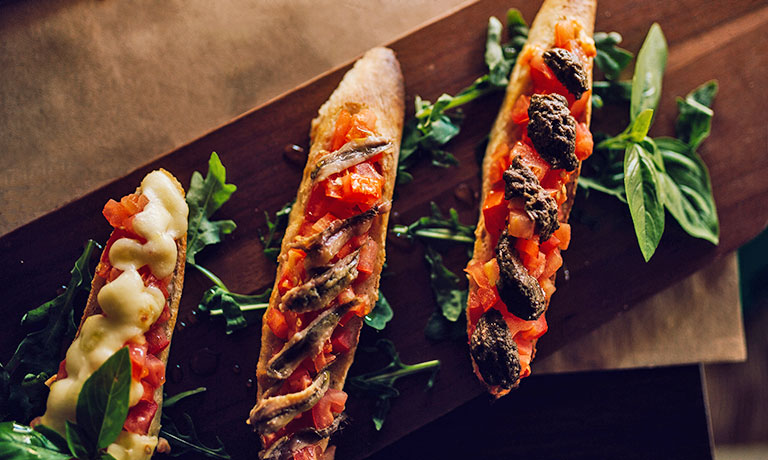 a group of tacos on a wood surface