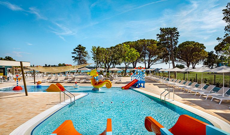 Ein Pool mit Rutsche und Stühlen