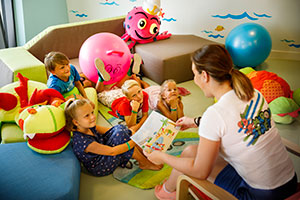 a person reading a book to a group of children