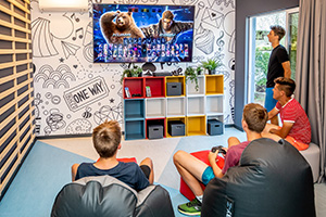 a group of people sitting in a room with a wall with art